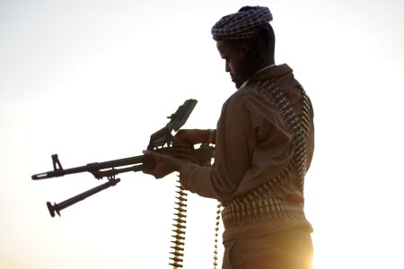 TO GO WITH AFP STORY BY JEAN-MARC MOJON A pirate loads his high caliber weapon in the early morning in the semi-desertic plains near the central Somalia town of Galkayo on August18, 2010. Fighting a losing battle against the sand that has already completely covered the old Italian port, Hobyo's scattering of rundown houses and shacks looks anything but the nerve centre of an activity threatening global shipping. Hobyo pirates have collected millions of dollars in ransoms over the past two years. They even have currency checking and counting machines for the bags of air-dropped cash they receive. AFP PHOTO / ROBERTO SCHMIDT (Photo credit should read ROBERTO SCHMIDT/AFP/Getty Images)