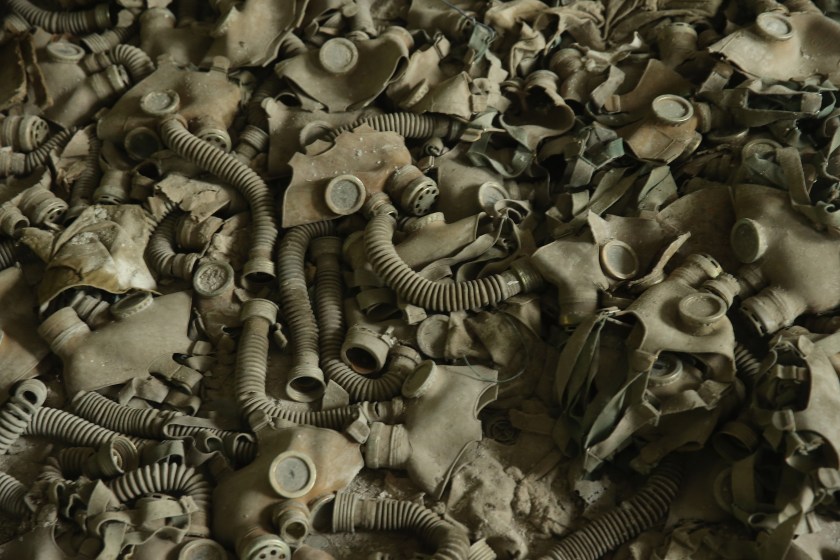 PRIPYAT, UKRAINE - SEPTEMBER 30: Cold War-era gas masks once common in the former Soviet Union lie strewn on the floor in a classroom of abandoned School Number 3 on September 30, 2015 in Pripyat, Ukraine. Pripyat lies only a few kilometers from the former Chernobyl nuclear power plant and was built in the 1970s to house the plant's workers and their families. On April 26, 1986, technicians at Chernobyl conducting a test inadvertently caused reactor number four to explode, sending plumes of highly radioactive particles and debris into the atmosphere. Authorities evacuated 120,000 people from the area, including 43,000 from Pripyat. Today Pripyat is a ghost-town, its apartment buildings, shops, restaurants, hospital, schools, cultural center and sports facilities derelict and its streets overgrown with trees. The city lies in the inner exclusion zone around Chernobyl where hot spots of persistently high levels of radiation make the area uninhabitable for thousands of years to come. (Photo by Sean Gallup/Getty Images)