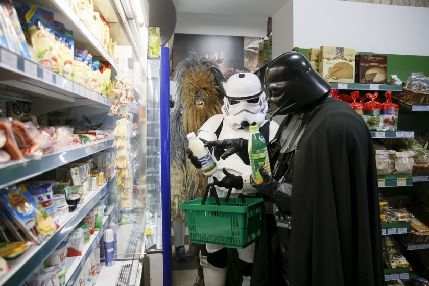 Darth Mykolaiovych Vader (R), who is dressed as the Star Wars character Darth Vader, and people dressed as Star Wars characters Chewbacca (L) and a Stormtrooper pose for a picture as they select products in a grocery store in Odessa, Ukraine, December 3, 2015. Darth Vader was bent on galactic domination, but his Ukrainian namesake enjoys more mundane pursuits: local politics, walking the family dog and a spot of embroidery. The Ukrainian citizen, who has changed his name to Darth Mykolaiovych Vader, ran for the post of local mayor in October, his political backers dressed as Stormtroopers. In his trademark black outfit, he is a regular sight around Odessa, a major port city on southern Ukraine's Black Sea coast. REUTERS/Valentyn Ogirenko PICTURE 7 OF 22 - SEARCH "VALENTYN VADER" FOR ALL IMAGES TPX IMAGES OF THE DAY - RTX1Y7XM