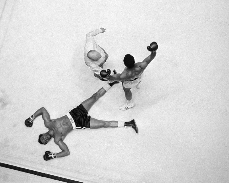 Cleveland Williams is spreadeagled on the canvas as referee Harry Kessler sends Muhammad Ali to a neutral corner during their heavyweight bout at the Astrodome in Houston, Nov. 14, 1966. (AP Photo)