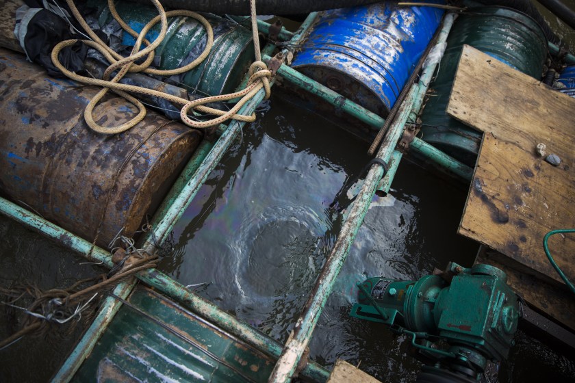 Oil slick floats below a rig at a sand dredging site near Kengtung, Shan State, Myanmar, on Thursday, Feb. 18, 2016. The recently-elected National League for Democracy has been vague about its plans for the country. Its economic platform pledged to do things such as expand the tax base and increase foreign investment, without saying how. (Taylor Weidman/Bloomberg via Getty Images)