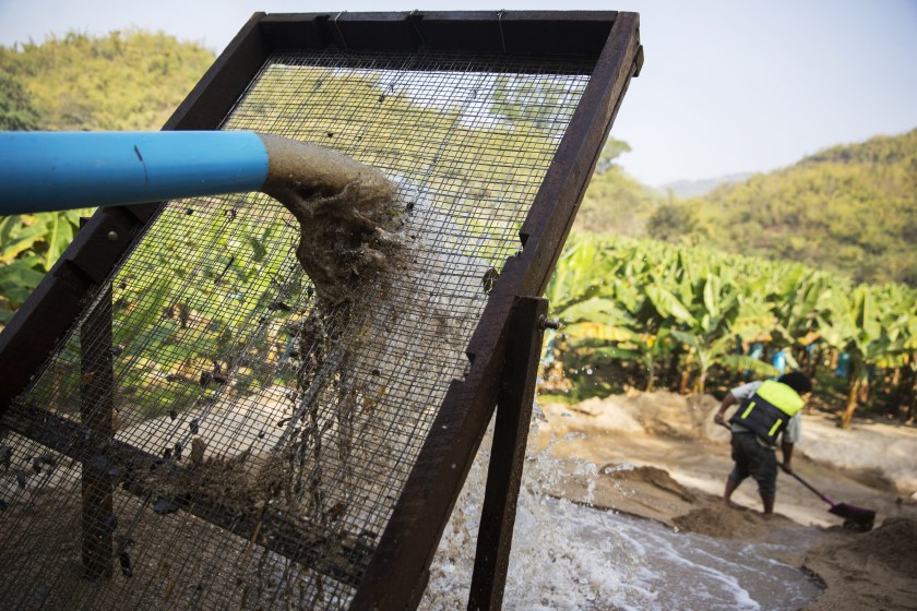 Slurry from a makeshift pipeline pours through a filter on the banks of a river at a sand dredging site near Kengtung, Shan State, Myanmar, on Thursday, Feb. 18, 2016. The recently-elected National League for Democracy has been vague about its plans for the country. Its economic platform pledged to do things such as expand the tax base and increase foreign investment, without saying how. (Taylor Weidman/Bloomberg via Getty Images)