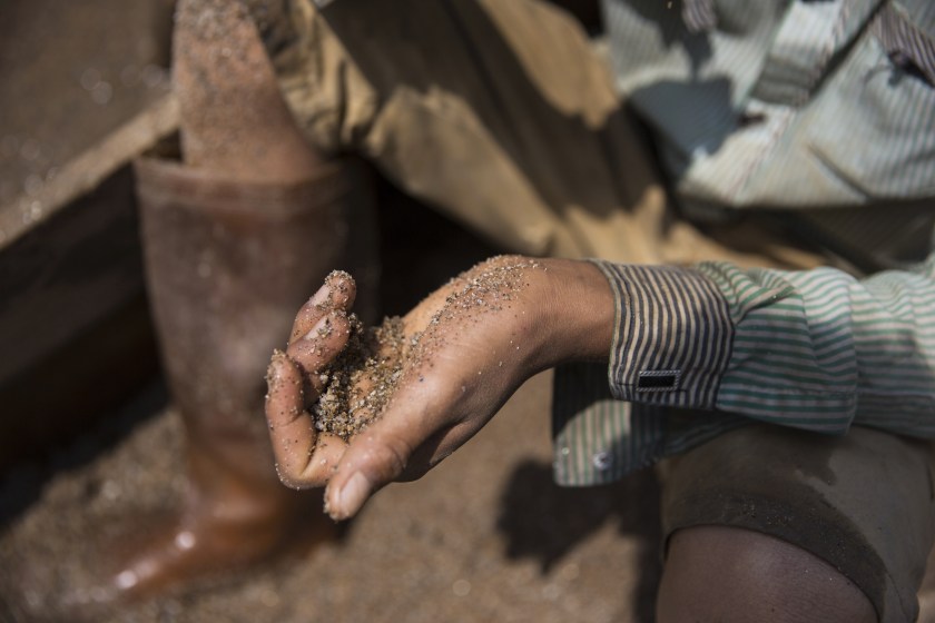 A worker holds a handful of sand on the banks of a river at a sand dredging site near Kengtung, Shan State, Myanmar, on Thursday, Feb. 18, 2016. The recently-elected National League for Democracy has been vague about its plans for the country. Its economic platform pledged to do things such as expand the tax base and increase foreign investment, without saying how. (Taylor Weidman/Bloomberg via Getty Images)