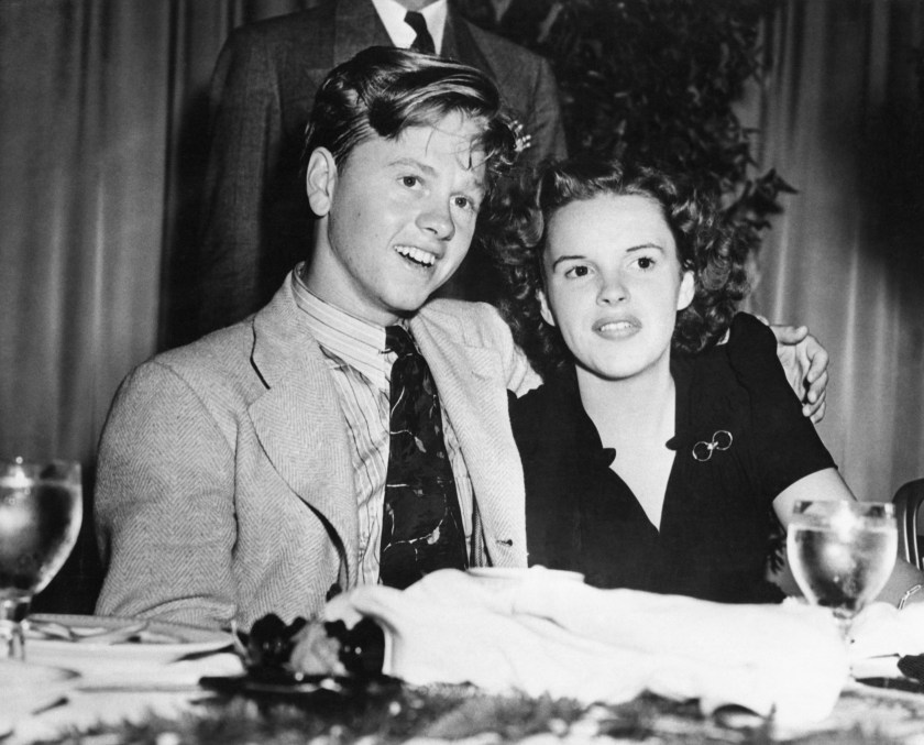 Judy Garland and Mickey Rooney, young screen stars here for personal appearances, are pictured in the Empire Room of the Waldorf-Astoria, Aug. 16th, where they had luncheon with a welcoming committee of 300 of their young loyal fans from various neighborhoods of New York City.