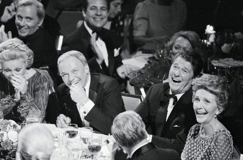 (Original Caption) Frank and Ron. New York: Frank Sinatra (left) and Ronald and Nancy Reagan share a laugh at a Republican "victory dinner" at New York's Waldorf Astoria. The affair was one of 19 $1,000-a-plate fund-raising affairs being held across the country. A closed-circuit television network emanating from three cities was set up to provide part of the program for all 19 cities.