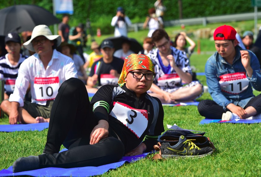 Dozens of citizens take part in Seoul's "space-out" competition in which participants are required to sit idly without talking, sleeping, eating, or using any electronic devices, at a riverside park in Seoul on May 22, 2016. The competition has gained popularity in South Korea since local artists organised the first edition in Seoul in 2014 as a satire of modern life dominated by social media and smartphones. / AFP / JUNG YEON-JE (Photo credit should read JUNG YEON-JE/AFP/Getty Images)
