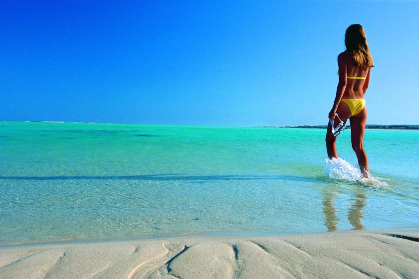 Girl walking into the water at Sandy Bay, Ningaloo Marine Park (Courtesy Western Australia Tourism)