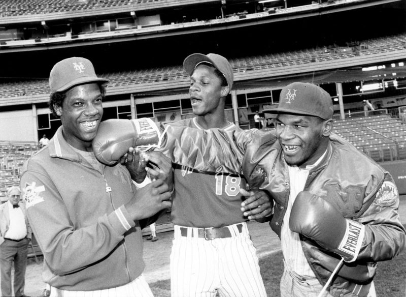 UNITED STATES - SEPTEMBER 10: New York Mets' Dwight Gooden laughs off a right from heavyweight Mike Tyson as referee Darryl Strawberry supervises the event at Shea Stadium. (Photo by Vincent Riehl/NY Daily News Archive via Getty Images)