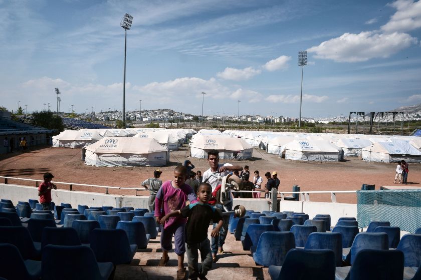 A family walks in the former Helliniko Olympic complex used as refugee camp for mainly Afghani refugees on May 10, 2016 in Athens southern suburb. (Louisa Gouliamaki/AFP/Getty Images)