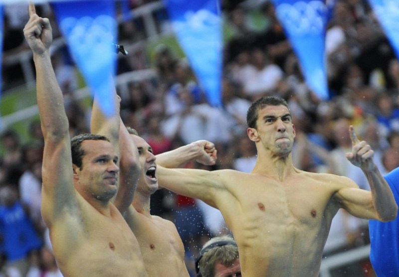 US swimmers Michael Phelps (R), Aaron Peirsol (C) and Brendan Hansen (L) react during the men's 4 x 100m medley relay swimming final at the National Aquatics Center during the 2008 Beijing Olympic Games in Beijing on August 17, 2008. Michael Phelps became the first man to win eight gold medals at the same Olympics when the US won the men's 4x100m medley relay final in a new world record time. AFP PHOTO / TIMOTHY CLARY (Photo credit should read TIMOTHY CLARY/AFP/Getty Images)