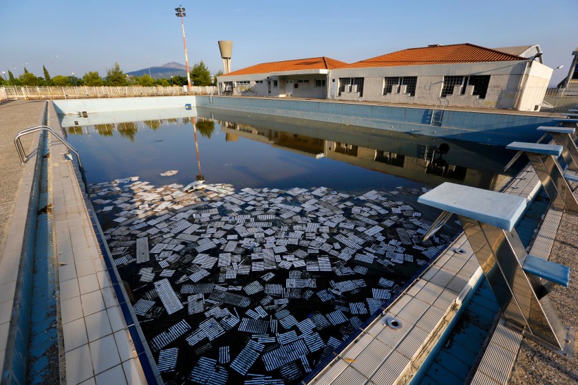 Garbage floats in a deserted swimming pool at the Olympic Village in Thrakomakedones, north of Athens July 25, 2014. Ten years after Greece hosted the world's greatest sporting extravaganza, many of its once-gleaming Olympic venues have been abandoned while others are used occasionally for non-sporting events such as conferences and weddings. For many Greeks who swelled with pride at the time, the Olympics are now a source of anger as the country struggles through a six-year depression, record unemployment, homelessness and poverty. Just days before the anniversary of the Aug. 13-29 Games in 2004, many question how Greece, among the smallest countries to ever host the Games, has benefited from the multi-billion dollar event. Picture taken July 25, 2014. REUTERS/Yannis Behrakis (GREECE - Tags: SOCIETY SPORT POLITICS BUSINESS) ATTENTION EDITORS: PICTURE 21 OF 33 FOR WIDER IMAGE PACKAGE 'TEN YEARS ON - ATHENS' FADING OLYMPIC STADIUMS' TO FIND ALL IMAGES SEARCH 'BEHRAKIS KARAHALIS' - RTR41JQL