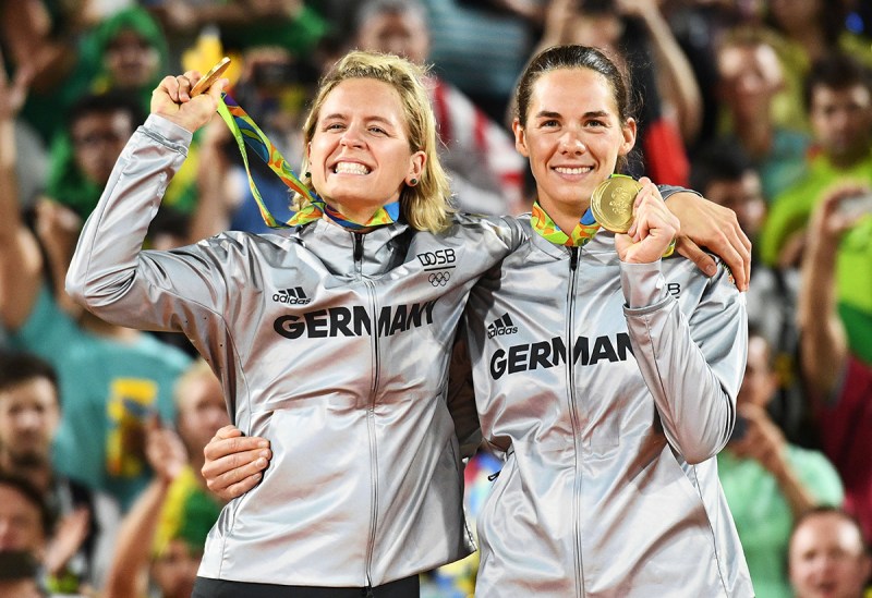 Germany's gold medallists, Laura Ludwig (L) and Kira Walkenhorst, celebrate on the podium at the end of the women's beach volleyball event. (Leon Neal/AFP/Getty Images)