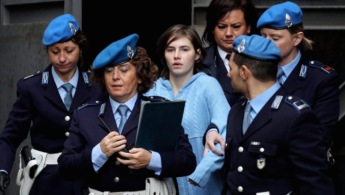 PERUGIA, ITALY - NOVEMBER 24:  Amanda Knox (C) is led away from Perugia's Court of Appeal by police officers after the first session of her appeal against her murder conviction on November 24, 2010 in Perugia, Italy. American Amanda Knox and her Italian ex-boyfriend Raffaele Sollecito were convicted of the murder of Ms Knox's former British flatmate Meredith Kercher in 2007. Their initial trial completed in December 2009 with Knox and Sollecito receiving sentences of 26 and 25 years respectively. Rudy Guede, an unemployed man from Ivory Coast, was also convicted of the murder of Meredith Kercher. The case is also forming the basis for a film currently being shot in Italy entitled 'The Amanda Knox Story', with American actress Hayden Panettiere cast as Amanda Knox.  (Photo by Oli Scarff/Getty Images)