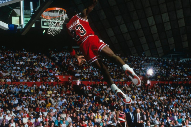 UNDATED: Chicago Bulls' forward Michael Jordan #23 jumps and dunks as the crowd takes photos during a game. NOTE TO USER: User expressly acknowledges and agrees that, by downloading and/or using this Photograph, user is consenting to the terms and conditions of the Getty Images License Agreement. (Photo by Focus on Sport/Getty Images) *** Local Caption *** Michael Jordan
