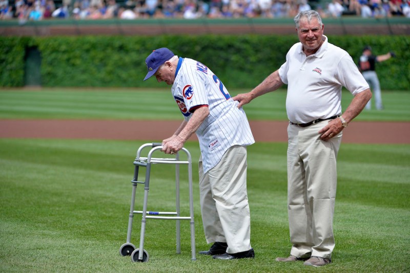 CHICAGO, IL - JUNE 7: Lennie Merullo (L), a member of the Chicago Cubs 1945 World Series team, is helped by his son Lennie Merullo Jr. as he walks onto the field to throw out a ceremonial first pitch before the Chicago Cubs Miami Marlins game at Wrigley Field June 7, 2014 in Chicago, Illinois. Merullo is the only surviving member of the Chicago Cubs who has ever played in a World Series game in a Cubs uniform. The Cubs defeated the Marlins 5-2. (Photo by Brian D. Kersey/Getty Images)