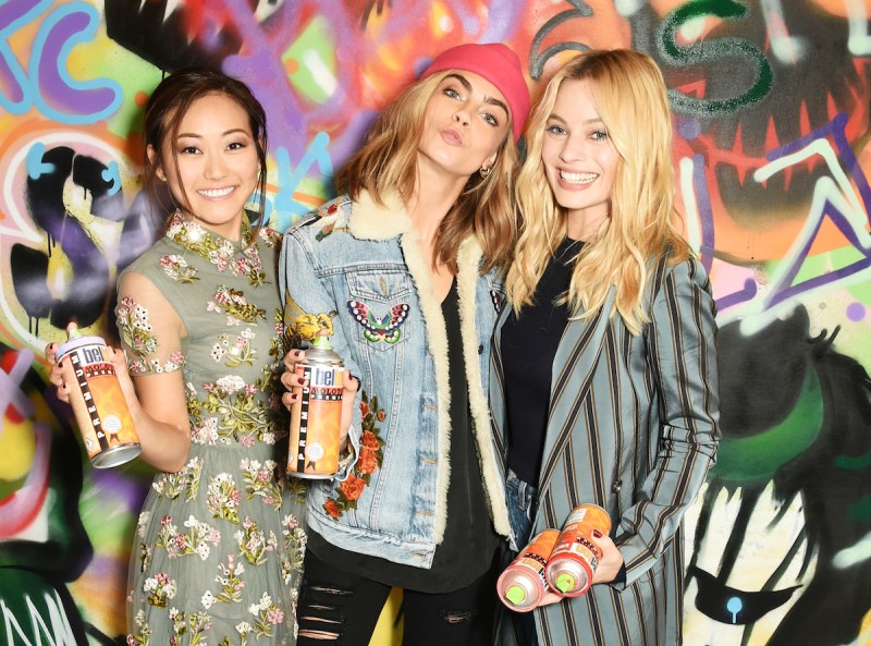 LONDON, ENGLAND - AUGUST 04: (L to R) Karen Fukuhara, Cara Delevingne, Margot Robbie and the cast of "Suicide Squad" put the finishing touches on Graffiti artist Ryan Meades' mural ahead of tomorrow's film release on August 4, 2016 in London, United Kingdom. (Photo by David M. Benett/Dave Benett/Getty Images for Warner Bros.)