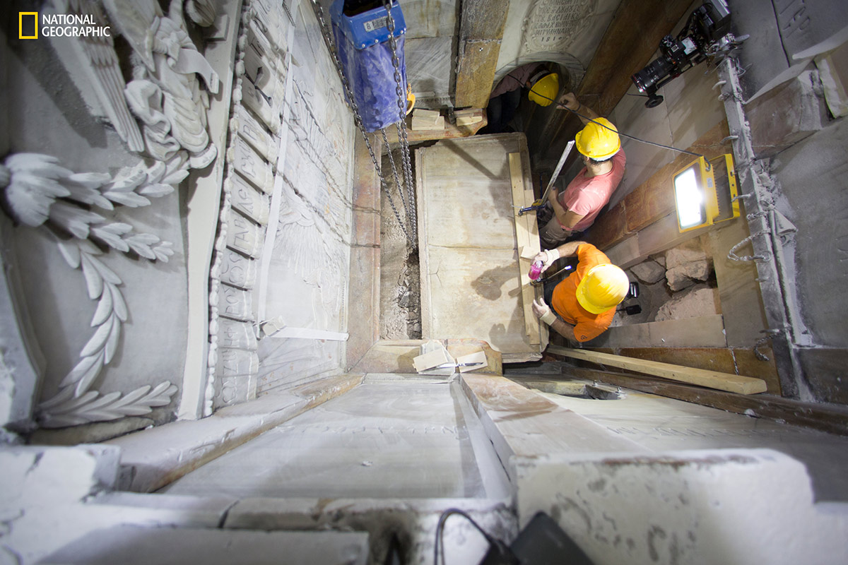 Workers begin removing the worn marble that has encased the original burial shelf for centuries, exposing a layer of fill material below. (Dusan Vranic/National Geographic)