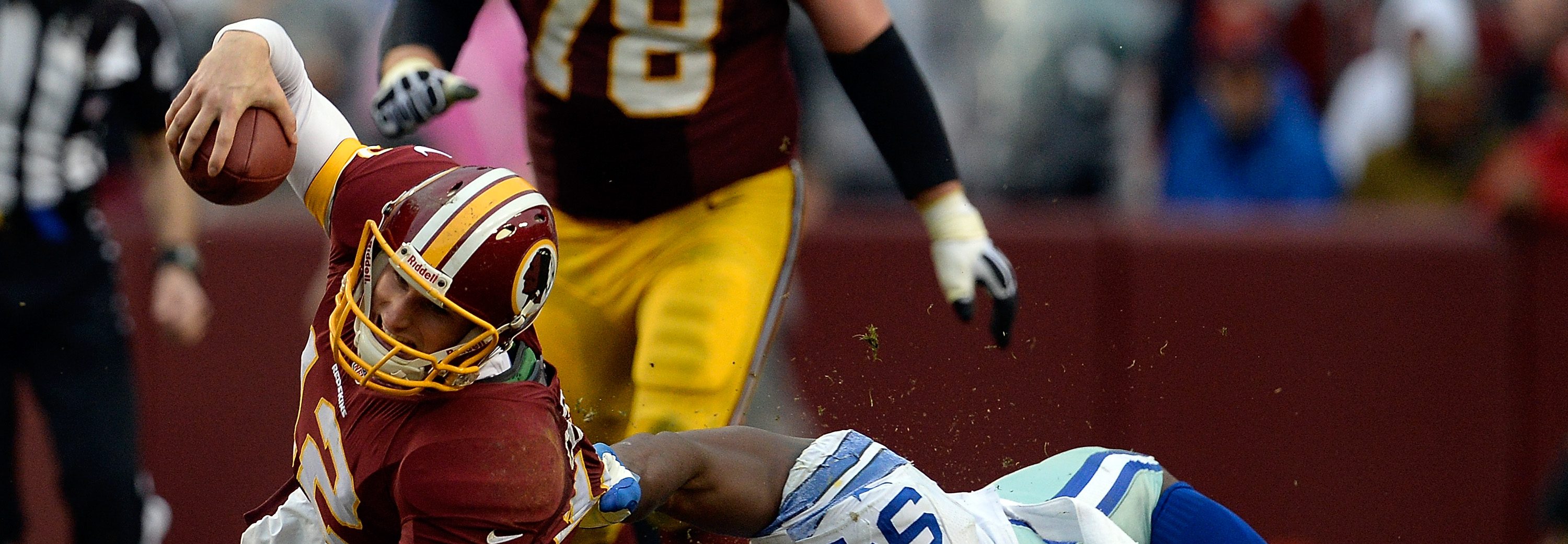 Quarterback Kirk Cousins #12 of the Washington Redskins is tackled by DeMarcus Ware #94 of the Dallas Cowboys in the second half during an NFL game at FedExField on December 22, 2013 in Landover, Maryland.  (Patrick McDermott/Getty Images)