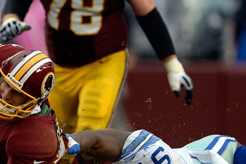 Quarterback Kirk Cousins #12 of the Washington Redskins is tackled by DeMarcus Ware #94 of the Dallas Cowboys in the second half during an NFL game at FedExField on December 22, 2013 in Landover, Maryland. (Patrick McDermott/Getty Images)
