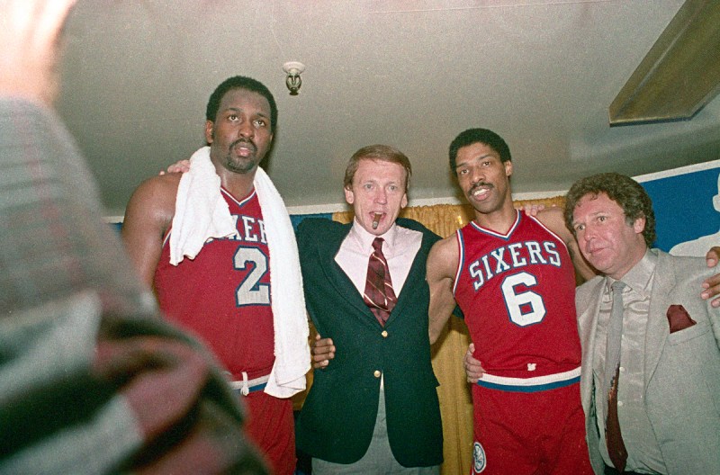 (Original Caption) Philadelphia 76ers' Moses Malone (2) and Julius Erving (6) hug their coach Bill Cunninham in the dressing room after the 76ers made a clear 4 game sweep over the Los Angeles Lakers to win the NBA Championship at the Forum 5/31, 115-108.