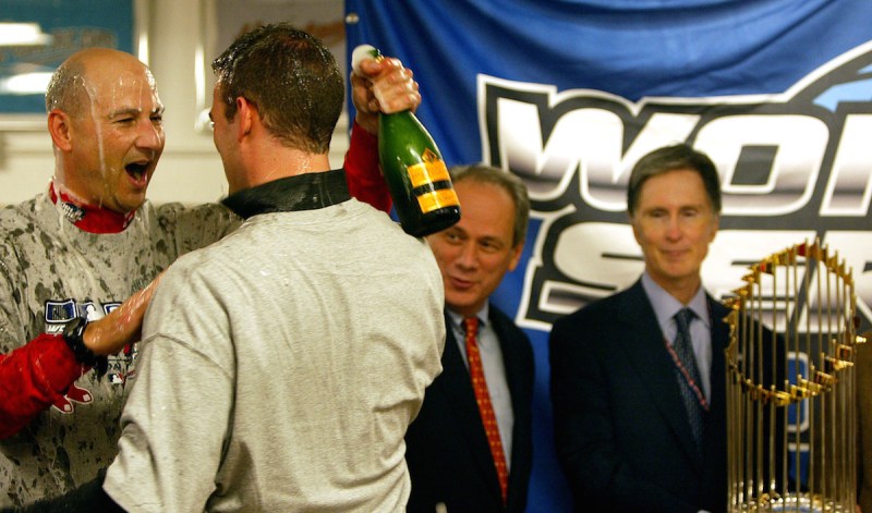 ST. LOUIS - OCTOBER 27: Terry Francona, Theo Epstein, Larry Lucchino, and John Henry with the trophy in the locker room. (Photo by Jim Davis/The Boston Globe via Getty Images)