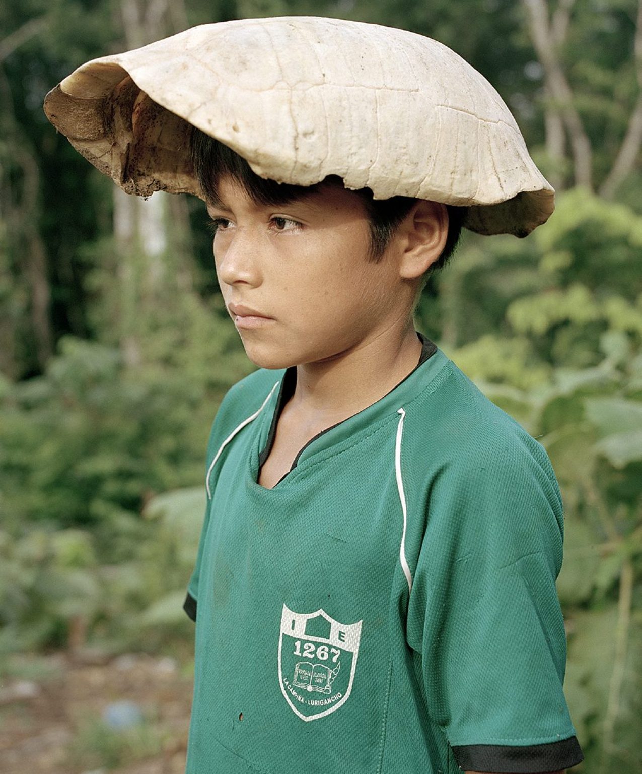 Turtle shell cap, Peru, 2012 (Yann Gross/Aperture) After lunch, a kid plays with a turtle shell, Bolívar Community, Peru. Turtle is one of the favorite meals in the Amazon.