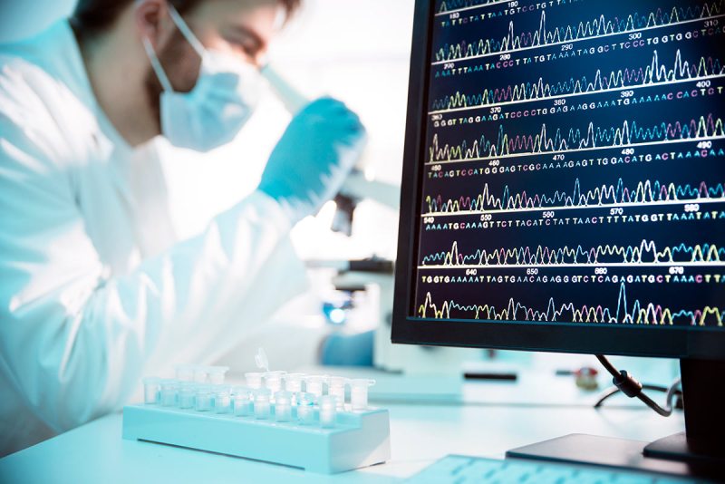 A DNA Sequence on a computer screen. Scientist in background (Getty Images)