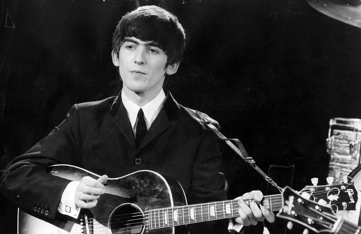 3rd December 1963: Guitarist and singer George Harrison (1943 - 2001) of the popular Merseybeat group The Beatles, performing during a live concert. (Fox Photos/Getty Images)