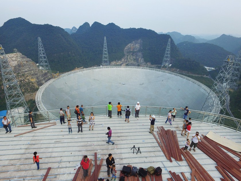 Aerial view of tourists looking at a dish-like radio telescope at Pingtang County on September 17, 2016, in Qiannan Buyei and Miao Autonomous Prefecture, Guizhou Province of China. After five years' construction, the 1,640-foot Aperture Spherical Telescope' (FAST) was put into use on Sept. 25. VCG/VCG via Getty Images)