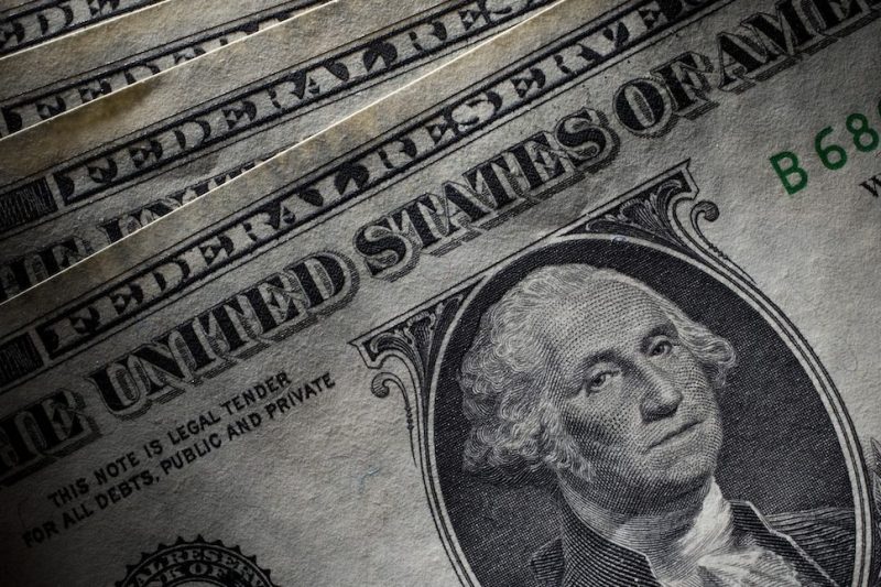 U.S. Dollar bills are arranged for a photograph in New York, U.S., on Tuesday, July 26, 2011.The dollar slid to a record low versus the Swiss franc, stocks fell and the cost of insuring U.S. debt rose to a 17-month high as Democrats and Republicans continued to wrangle over competing plans to cut the deficit. Photographer: Scott Eells/Bloomberg