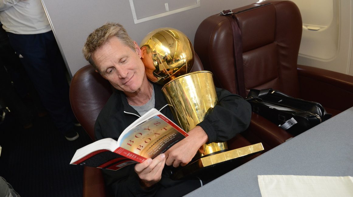 OAKLAND, CA - JUNE 17:  Steve Kerr of the Golden State Warriors holds the NBA trophy on the plane as the team travels home from Cleveland after winning the 2015 NBA Finals on June 17, 2015 in Oakland, California. NOTE TO USER: User expressly acknowledges and agrees that, by downloading and/or using this Photograph, user is consenting to the terms and conditions of the Getty Images License Agreement. Mandatory Copyright Notice: Copyright 2015 NBAE (Photo by Noah Graham/NBAE via Getty Images)