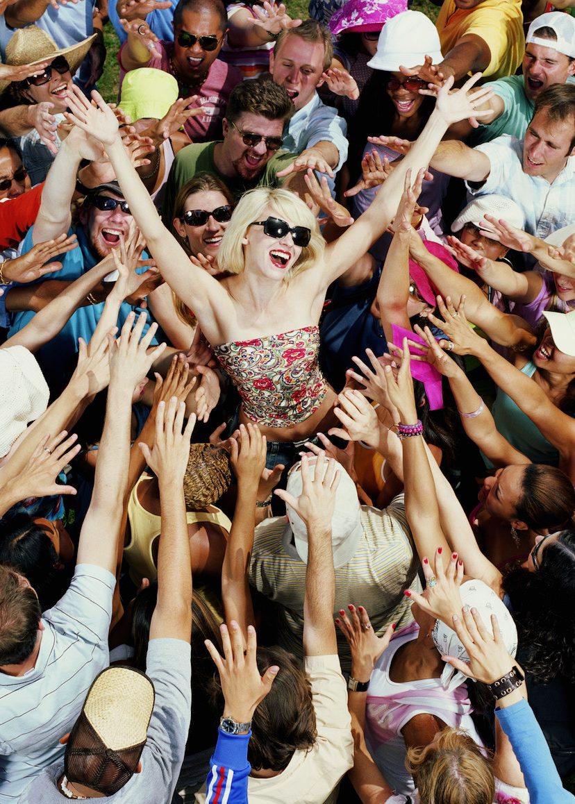 Young adults reaching for female celebrity, elevated view (Getty Images)