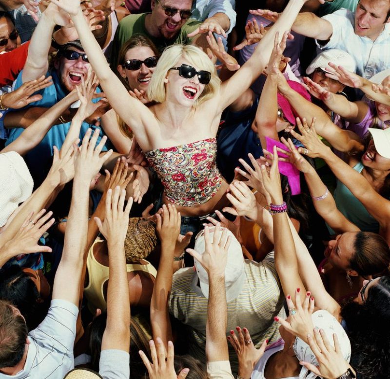 Young adults reaching for female celebrity, elevated view (Getty Images)