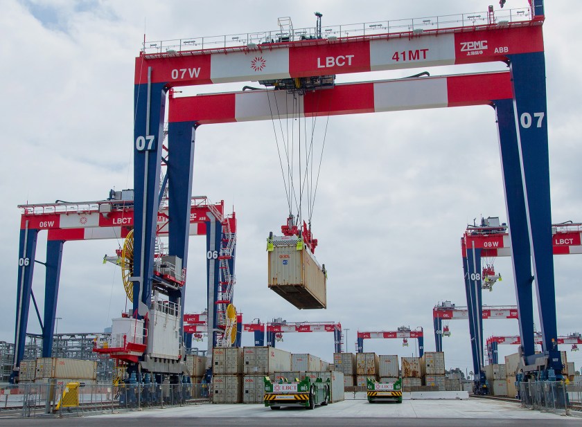 Containers are loaded onto automated guided vehicles (AGV) during the testing phase of the Long Beach Container Terminal in Middle Harbor at the Port of Long Beach in Long Beach, California, U.S., on Wednesday, May 13, 2015. Next year, deckhands on ships docked at Middle Harbor on California's San Pedro Bay won't see many people on the wharf. Remote-controlled cranes towering 165 feet overhead will pluck containers from vessels' holds, and driverless trucks guided by magnets embedded in the asphalt will carry cargo to robotic hoists in a sorting yard. (Tim Rue/Bloomberg via Getty Images)