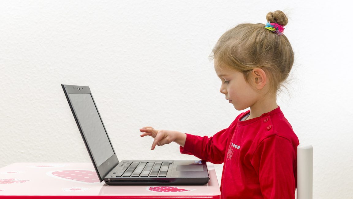 WUERZBURG, BAVARIA, GERMANY - 2014/12/21: A blond three year old girl is sitting in front of a notebook, laptop, watching the screen and using the keyboard. (Photo by Frank Bienewald/LightRocket via Getty Images)