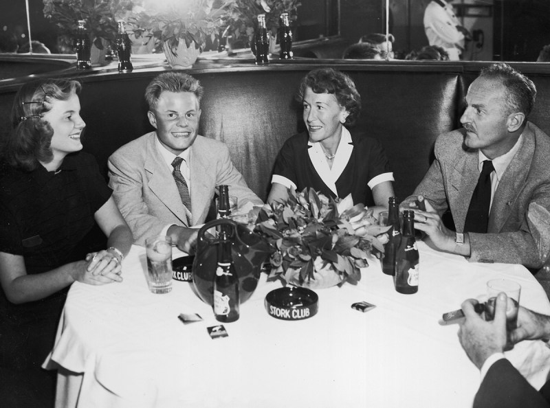 American film executive, producer, screenwriter and director Darryl F Zanuck (right), sits beside his wife, Virginia Fox Zanuck, and their two children, Darrylin and Richard Darryl, in a booth at the Stork Club in New York City. (Hulton Archive/Getty Images)