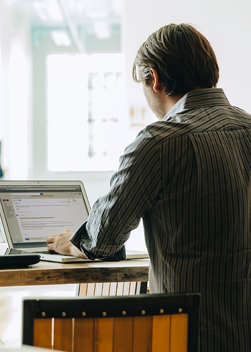 Caucasian businessman using laptop in office (Getty Images)