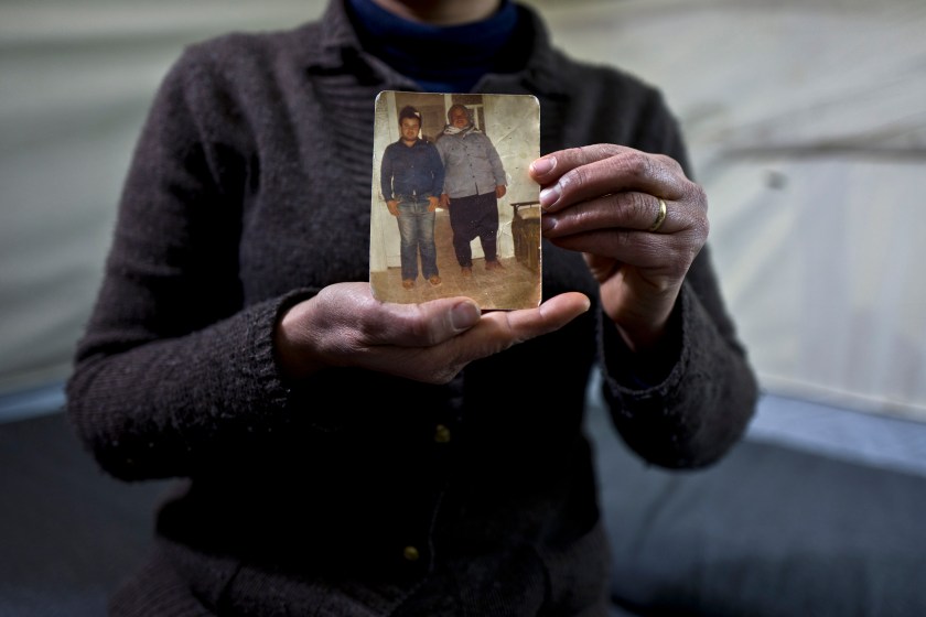 In this Wednesday, Jan. 18, 2017 photo, Habeeba Waqas, 40, a Syrian refugee from Aleppo, holds a photograph showing her husband Mohammed and her father in law Suliman at her tent in Frakapor refugee camp on the outskirts of the northern Greek city of Thessaloniki. "This is the only memory that I carried with me from Syria, my husband was young and handsome in this picture." Habeeba said. (AP Photo/Muhammed Muheisen)
