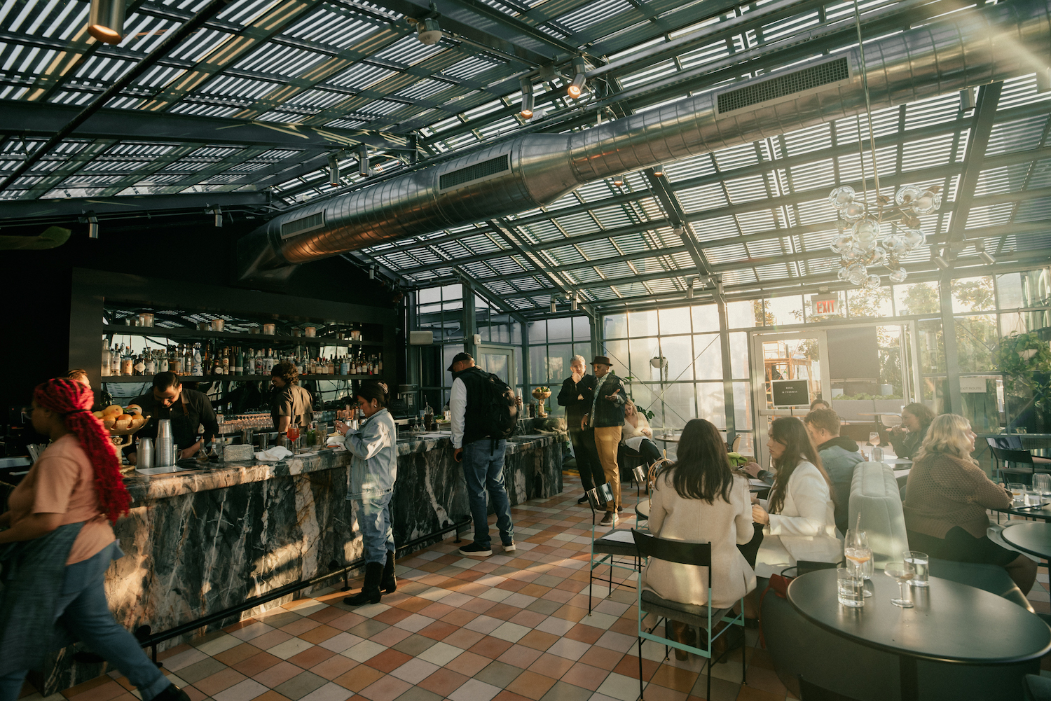 Interior of Rise Over Run bar, with full glass windows along the floor and ceiling and low top tables