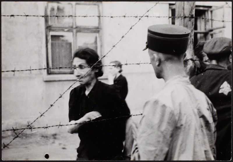 Lodz ghetto: Ghetto police with woman behind barbed wire (Henryk Ross/Art Gallery of Ontario)