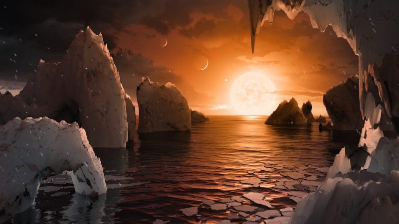 UNSPECIFIED: In this NASA digital illustration handout released on February 22, 2017, an artist's concept allows us to imagine what it would be like to stand on the surface of the exoplanet TRAPPIST-1f, located in the TRAPPIST-1 system in the constellation Aquarius. Because this planet is thought to be tidally locked to its star, meaning the same face of the planet is always pointed at the star, there would be a region called the terminator that perpetually divides day and night. If the night side is icy, the day side might give way to liquid water in the area where sufficient starlight hits the surface. One of the unusual features of TRAPPIST-1 planets is how close they are to each other -- so close that other planets could be visible in the sky from the surface of each one. In this view, the planets in the sky correspond to TRAPPIST1e (top left crescent), d (middle crescent) and c (bright dot to the lower right of the crescents). TRAPPIST-1e would appear about the same size as the moon and TRAPPIST1-c is on the far side of the star. The star itself, an ultra-cool dwarf, would appear about three times larger than our own sun does in Earth's skies. The system has been revealed through observations from NASA's Spitzer Space Telescope as well as other ground-based observatories, and the ground-based TRAPPIST telescope for which it was named after. (Photo digital Illustration by NASA/NASA via Getty Images)