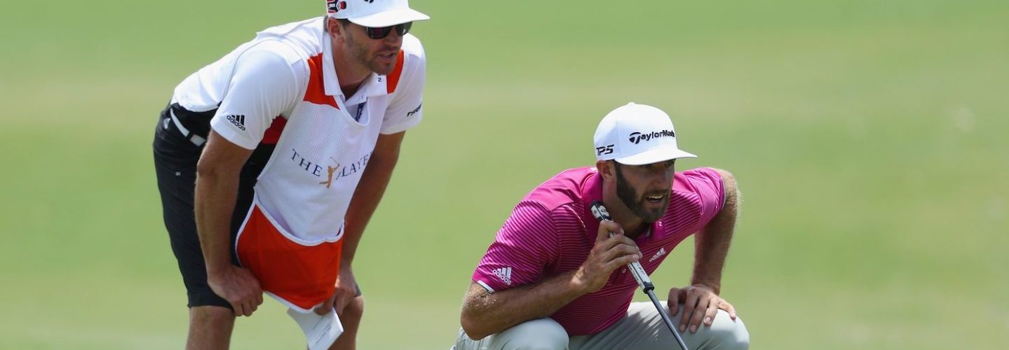 Dustin Johnson and his brother/caddie Austin line up a putt at THE PLAYERS Championship on May 12, 2017. (Warren Little/Getty Images)