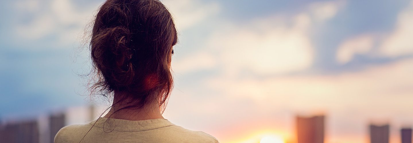 Young girl is watching sunset over Tokyo in Odaiba.