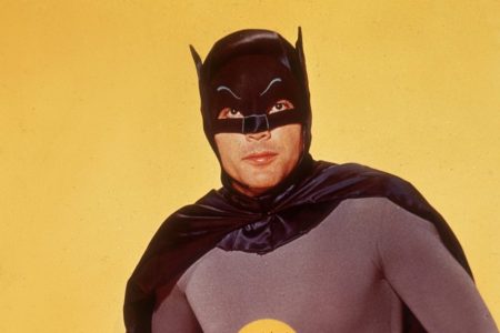 Actor Adam West poses in costume as Batman in front of a yellow backdrop in a promotional portrait for the television series, 'Batman'. (Photo by Hulton Archive/Getty Images)