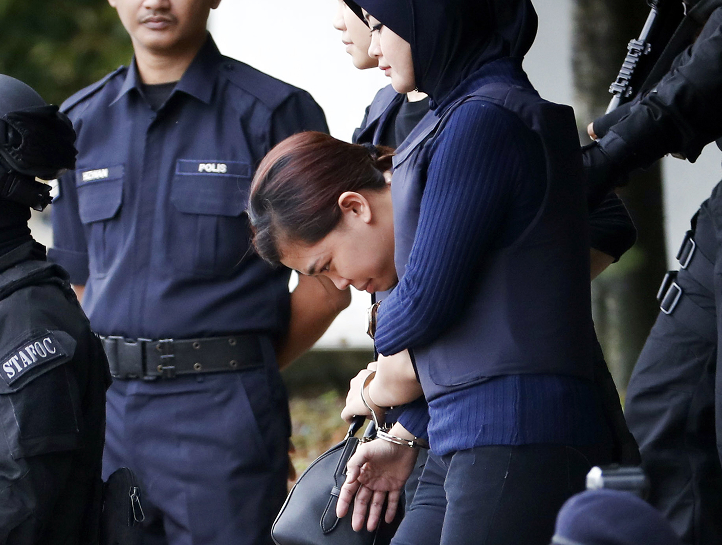 In this Thursday, April 13, 2017 photo, Indonesian suspect Siti Aisyah, center, arrested in the death of Kim Jong Nam, is escorted by police officers as she leaves a court house in Sepang, Malaysia.