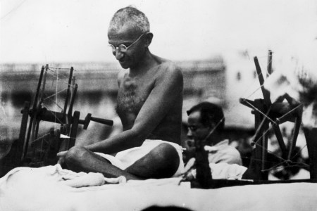 Indian Nationalist leader Mahatma Gandhi (Mohandas Karamchand Gandhi, 1869 - 1948) at a spinning wheel during a 'Charlea' demonstration in Mirzapur, Uttar Pradesh.  (Hulton Archive/Getty Images)