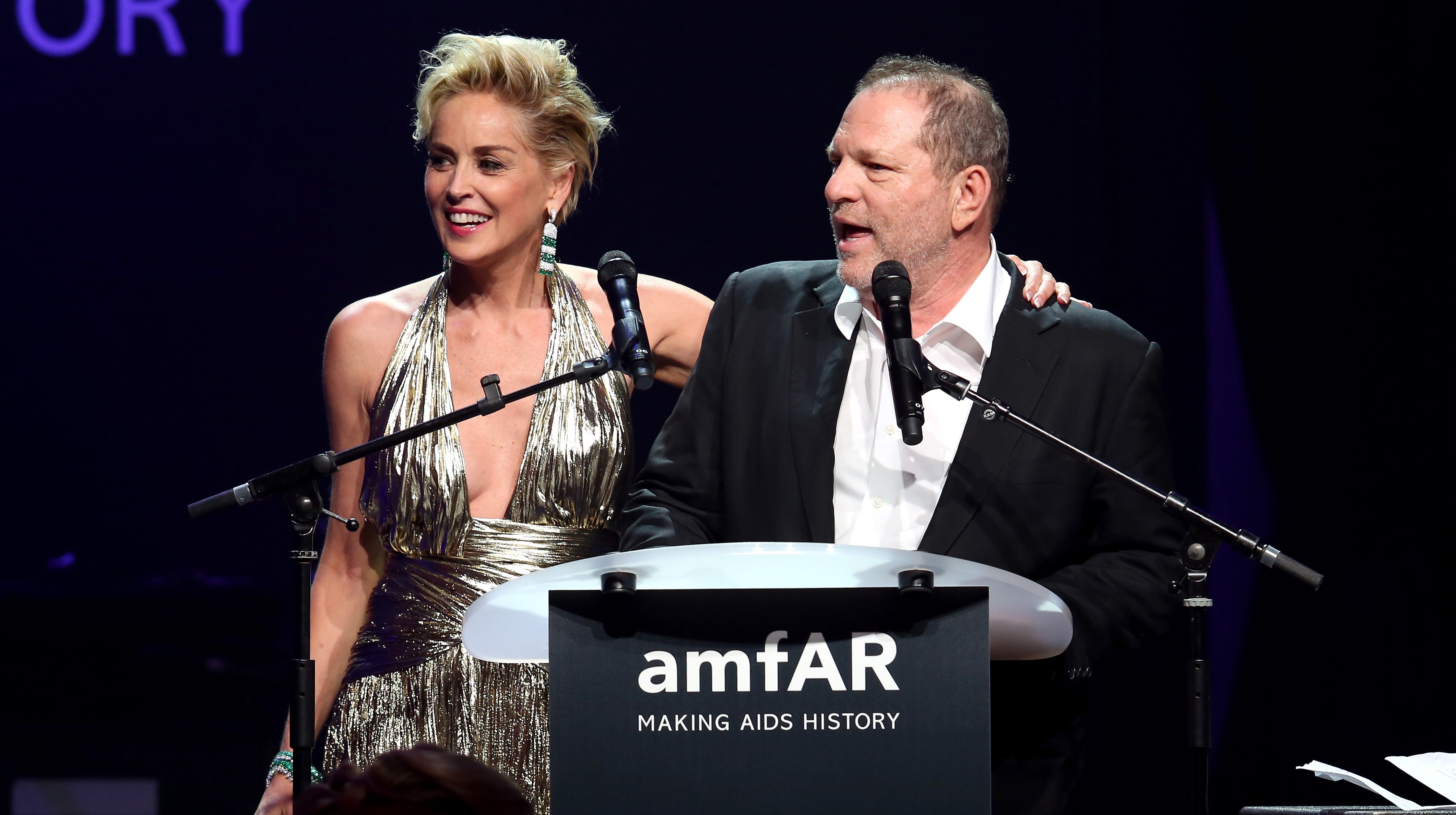 Sharon Stone (L) and Harvey Weinstein speak onstage during amfAR's 21st Cinema Against AIDS Gala Presented By WORLDVIEW, BOLD FILMS, And BVLGARI at Hotel du Cap-Eden-Roc on May 22, 2014 in Cap d'Antibes, France.  (Photo by Tim P. Whitby/Getty Images for amfAR)