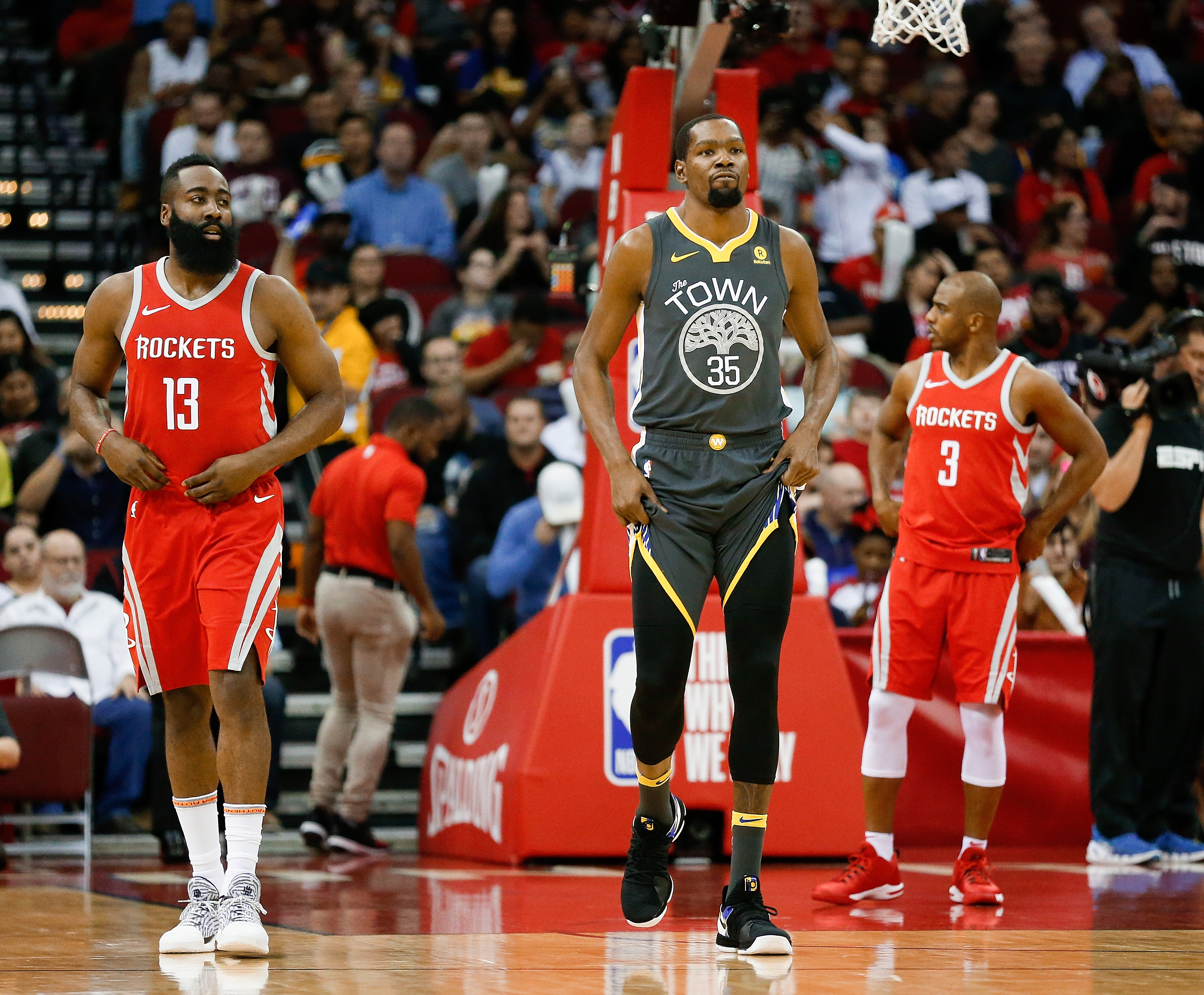 James Harden #13 of the Houston Rockets, Kevin Durant #35 of the Golden State Warriors and Chris Paul #3 of the Houston Rockets at Toyota Center on January 20, 2018 in Houston, Texas. NOTE TO USER: User expressly acknowledges and agrees that, by downloading and or using this photograph, User is consenting to the terms and conditions of the Getty Images License Agreement.  (Photo by Bob Levey/Getty Images)