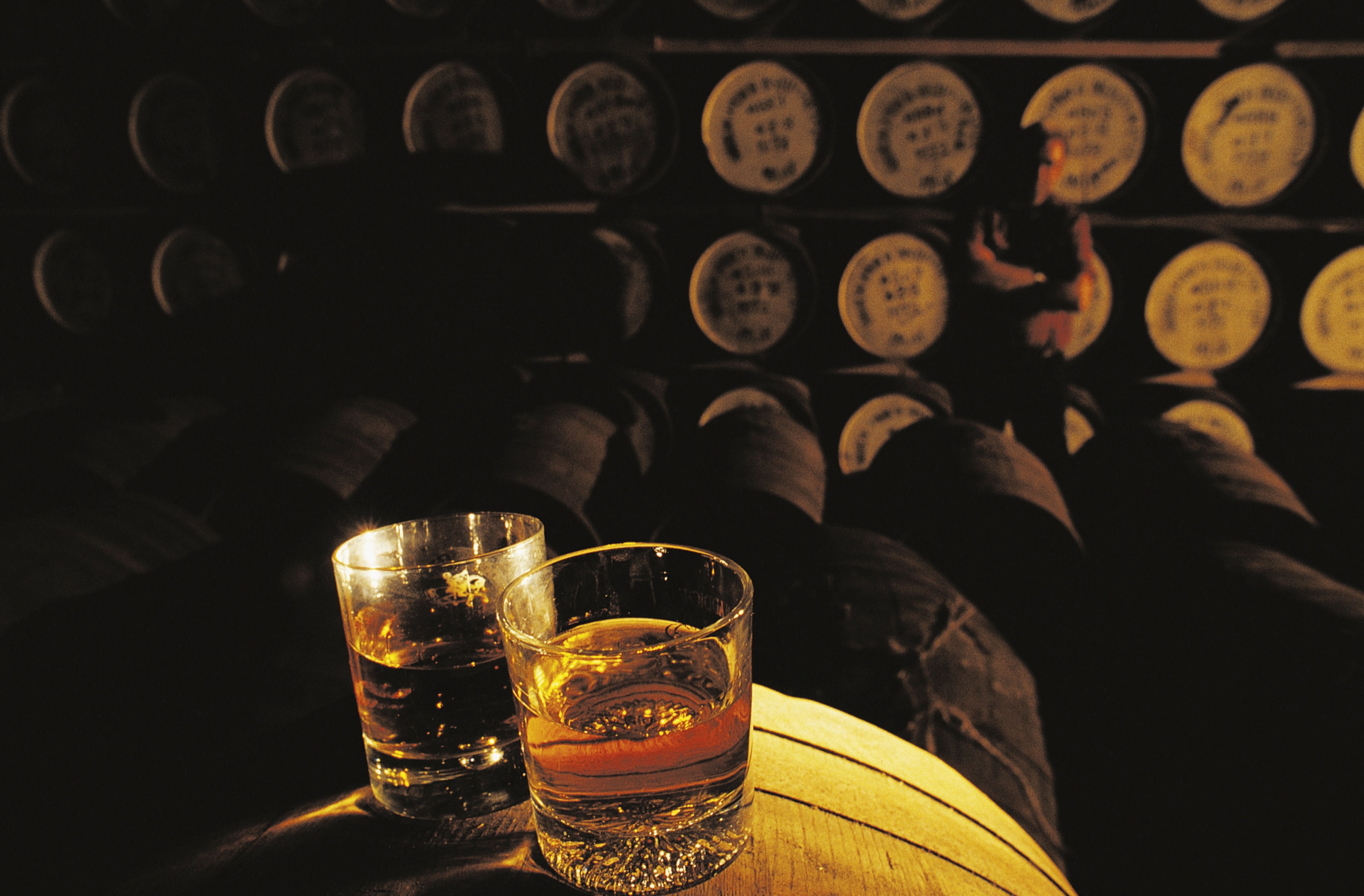 Whiskey glasses on a barrel in a whiskey distillery, Hebrides, United Kingdom.