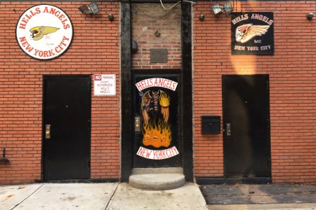 A sign near the front door of the Hells Angels motorcycle club headquarters in New York reads "No Parking Except Authorized Hells Angels," Friday, Dec. 16, 2016. Earlier in the week an out-of-town man was shot after moving an orange cone meant to save a parking space for club members. The secretive group has frustrated police by refusing to help identify the shooter. (AP Photo/Tom Hays)